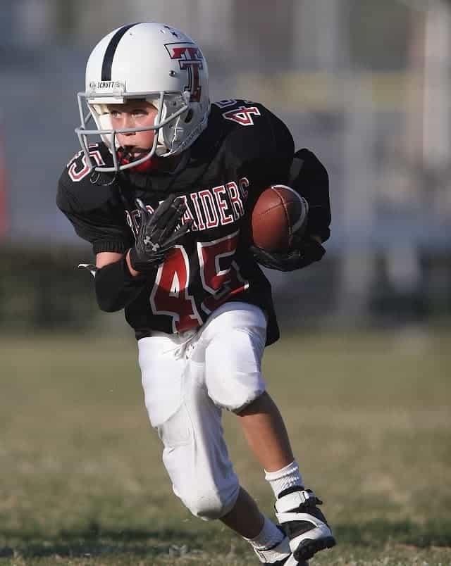 Boy running with football