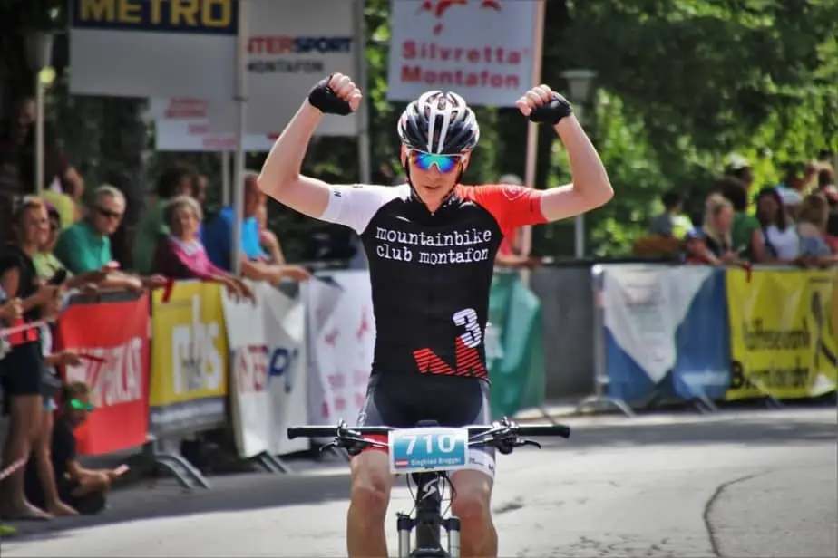 Cyclist raising arms winning race