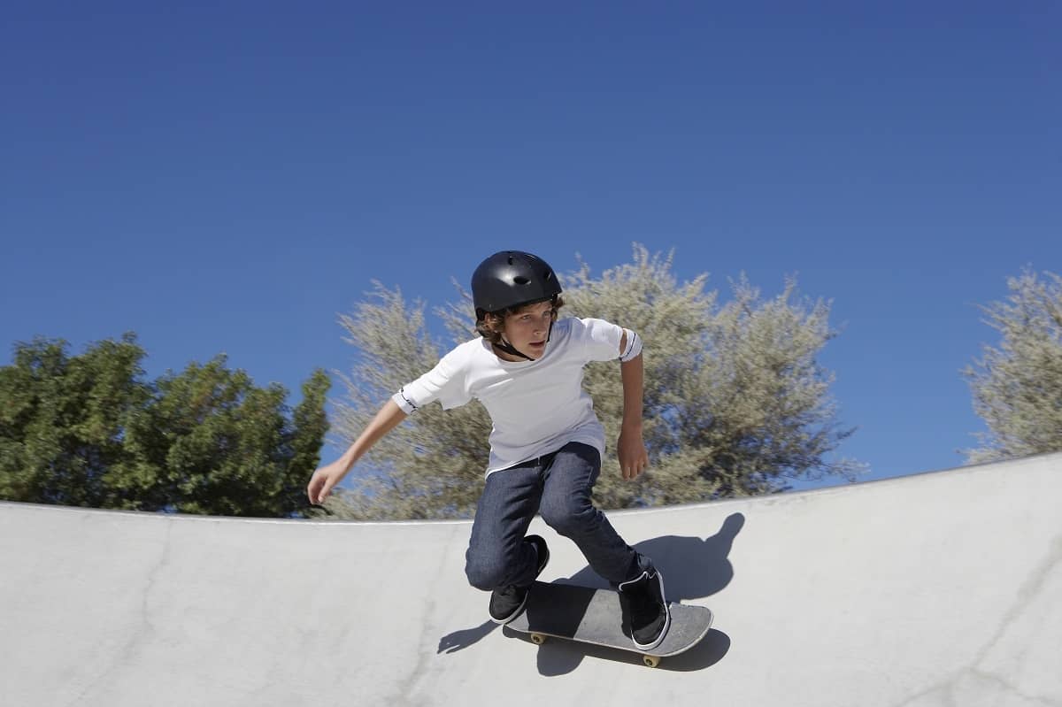 Teenage boy riding skateboard wearing a helmet