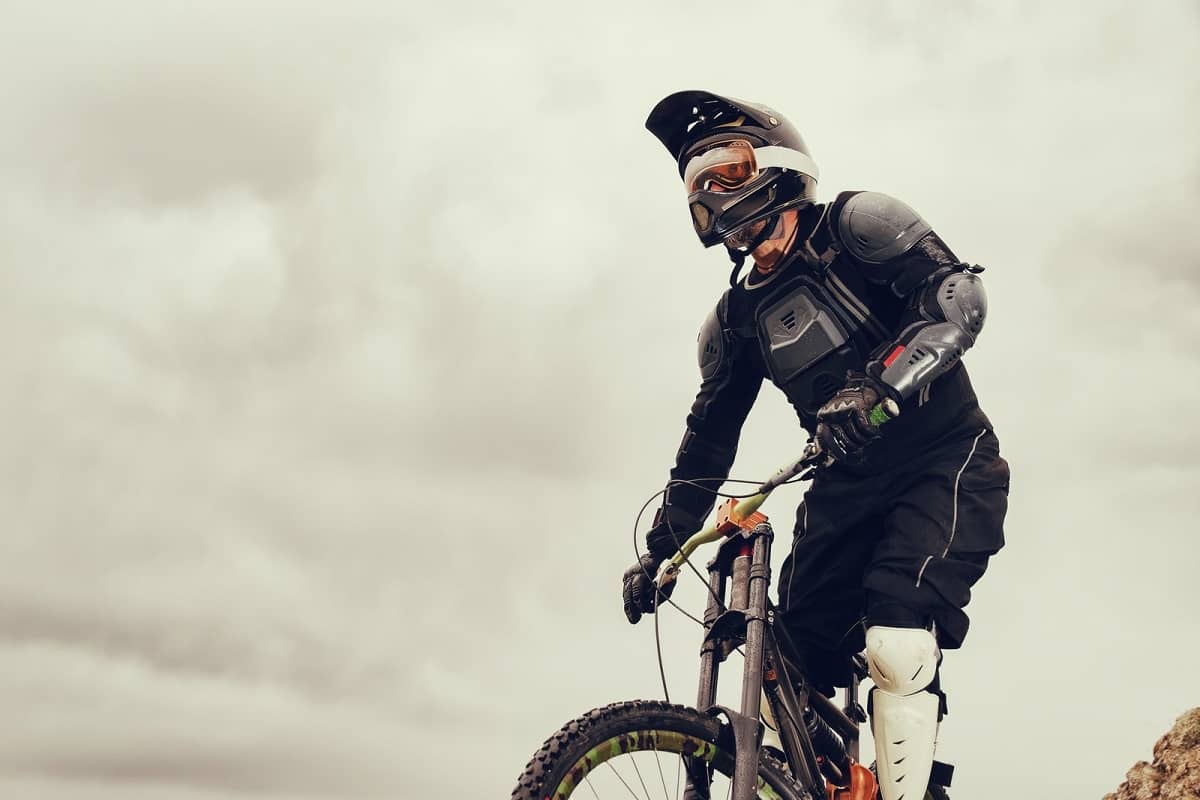 Mountain biker wearing full padding and full-face helmet.