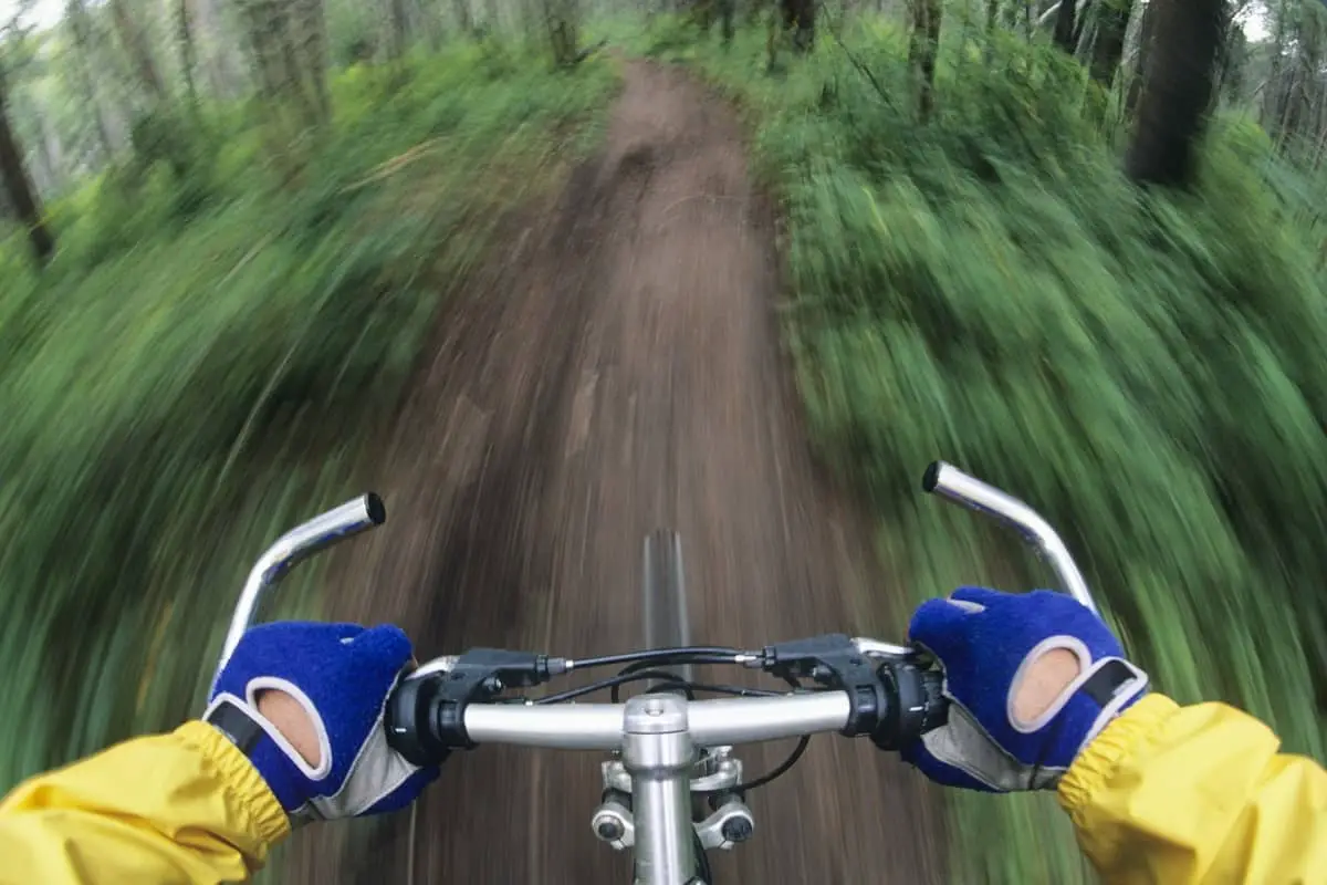 Mountain bike riders view riding down trail at speed.