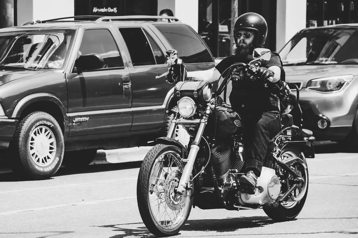 Bearded guy riding Harley Davidson motorcycle in city