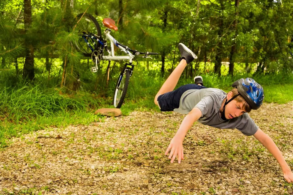 Boy flying through the air after hitting rock with bicycle