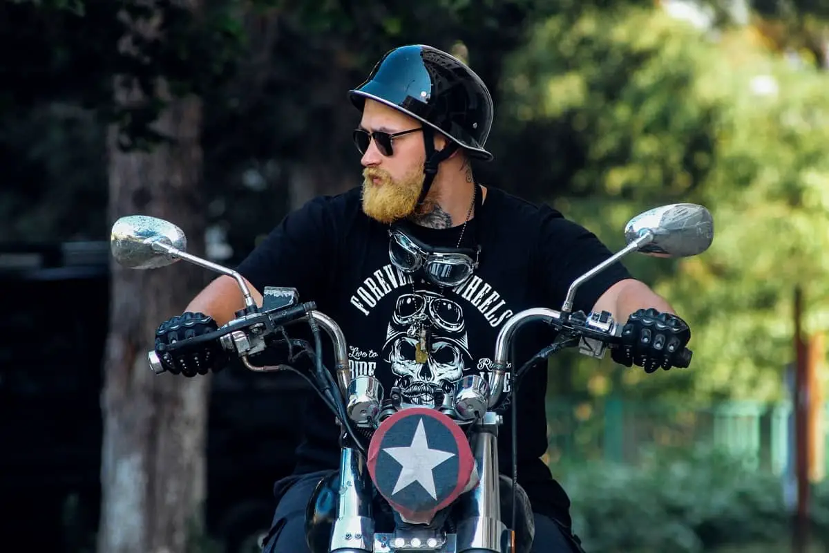 Bikie guy wearing German style motorcycle helmet on chopper bike