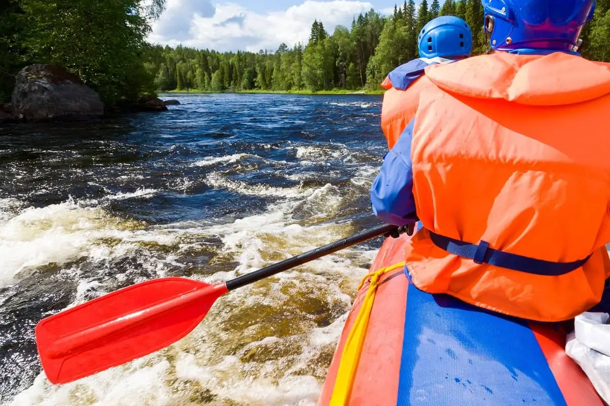 Kayakers paddling along river