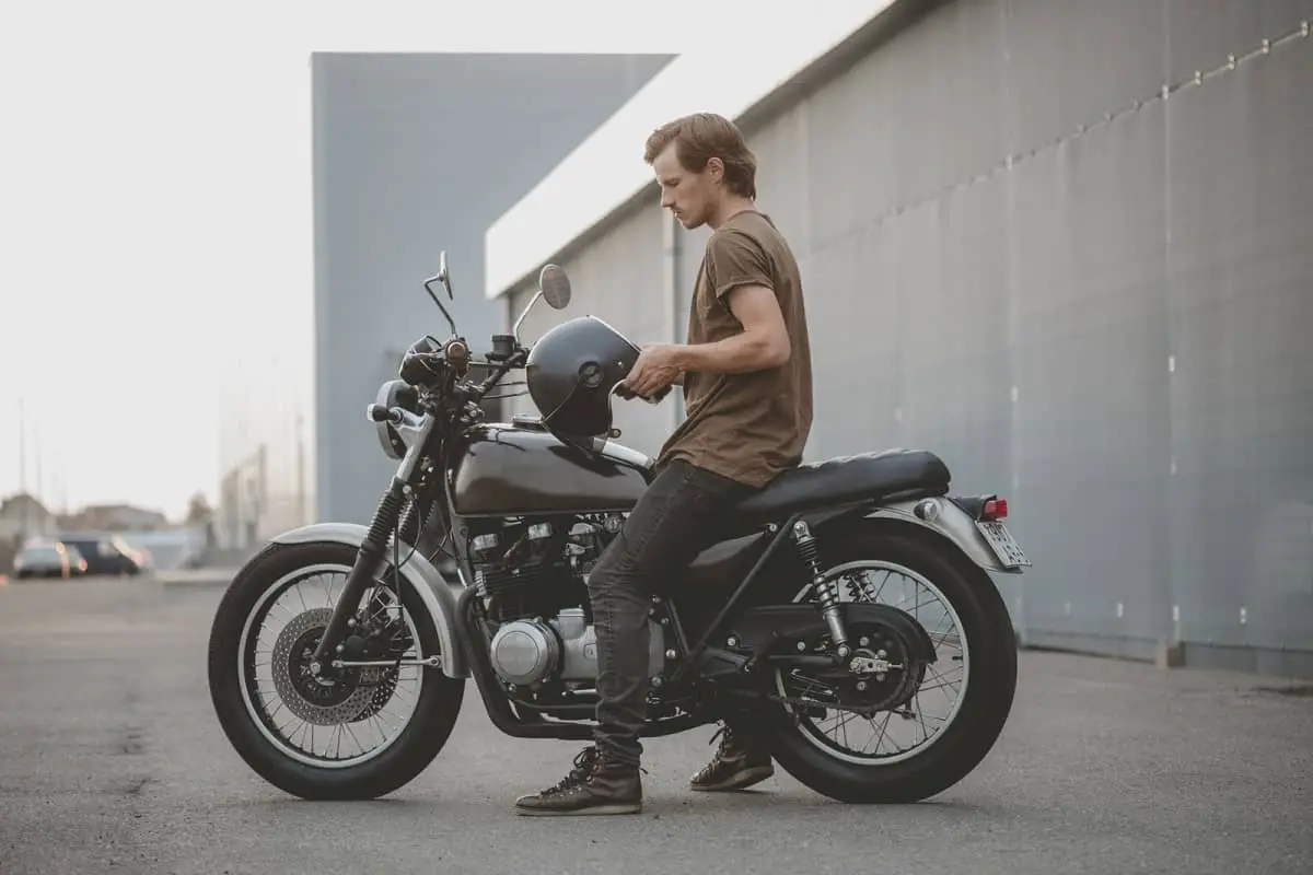 man on motorcycle adjusting helmet