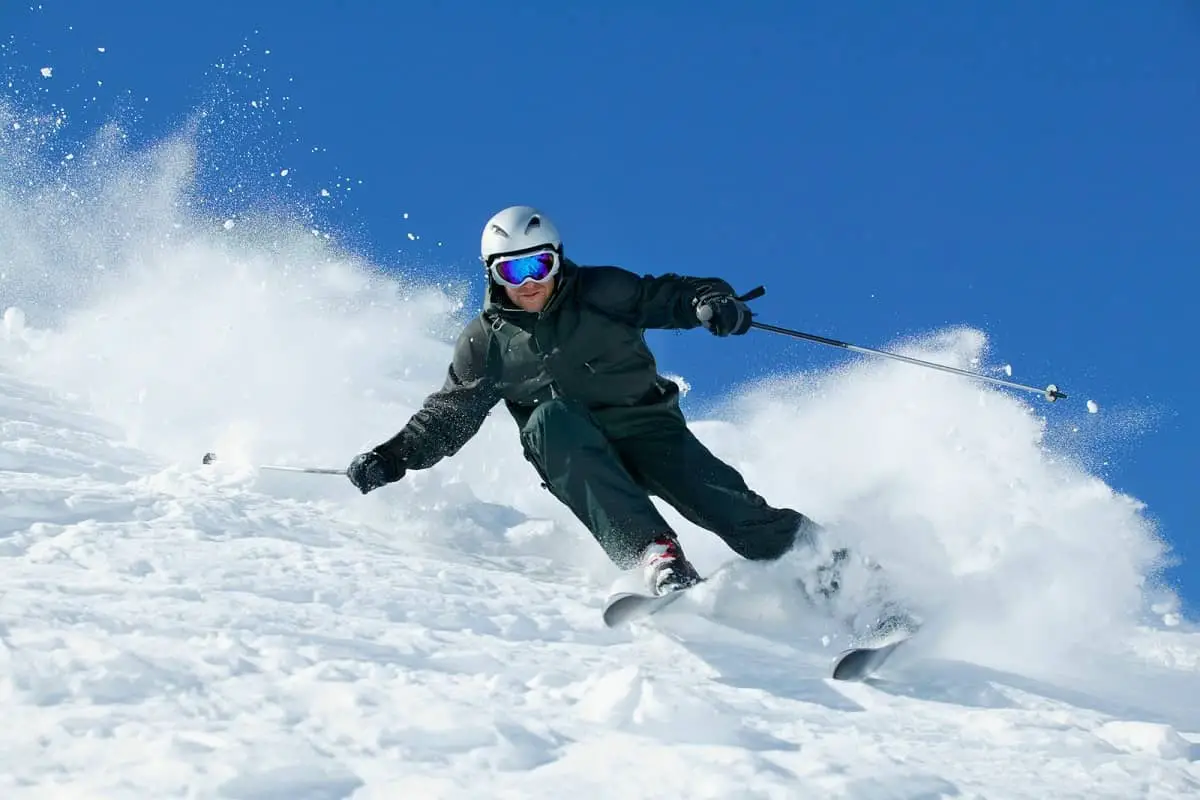 Man skiing down steep hill wearing a helmet