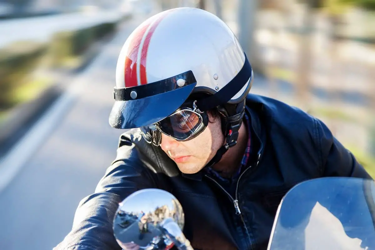 Young person wearing peaked helmet on motorcycle