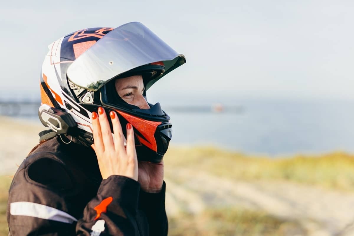 woman putting mx helmet on her head