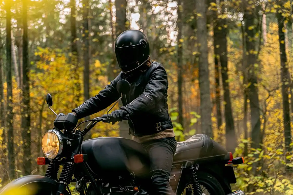 Tinting motorcycle helmet visor yourself.  Man on motorbike wearing helmet with dark tint.
