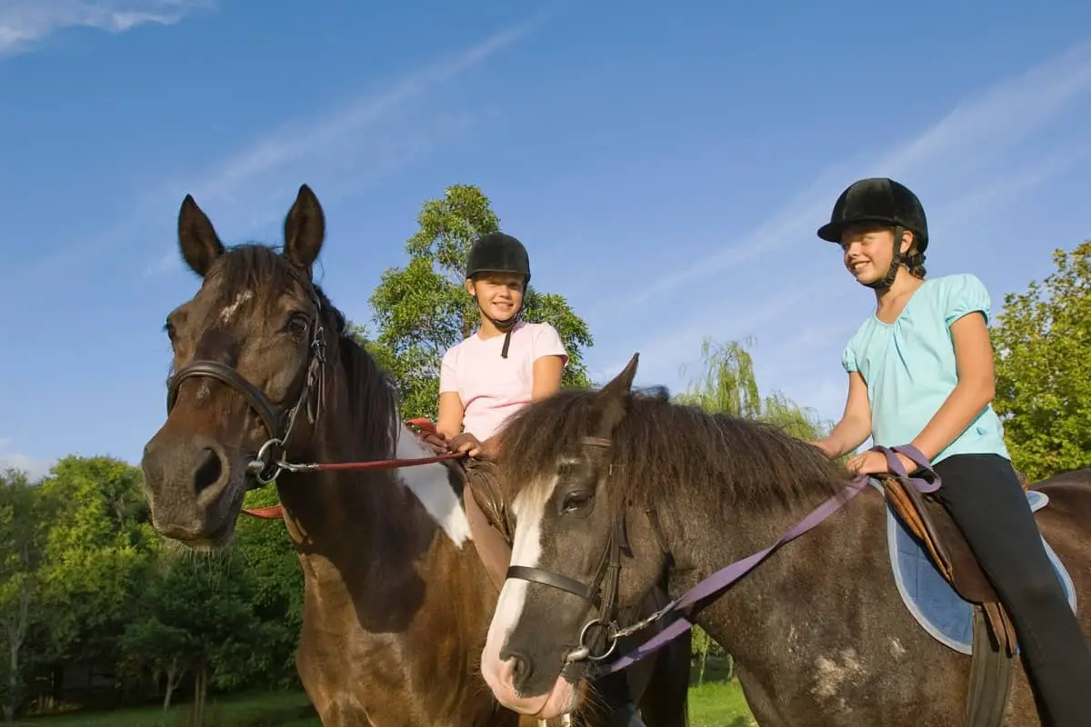 Two pre-teen girls riding horses