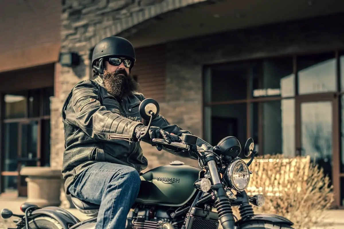 Bearded biker sitting on triumph motorcycle