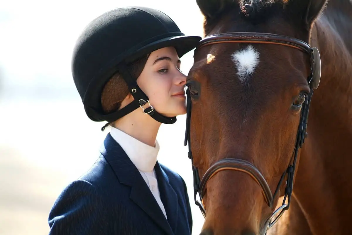 Girl about to kiss horses head