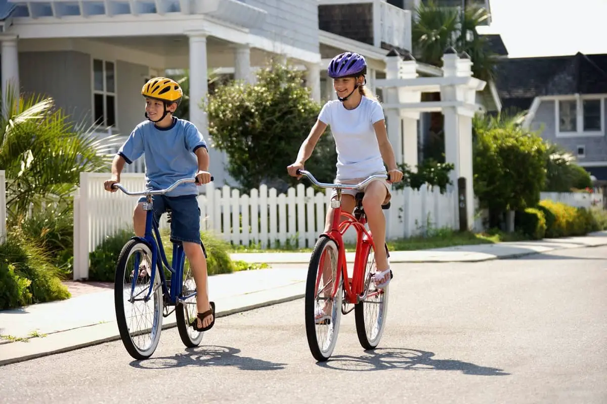 Two teenagers riding bikes wearing helmets