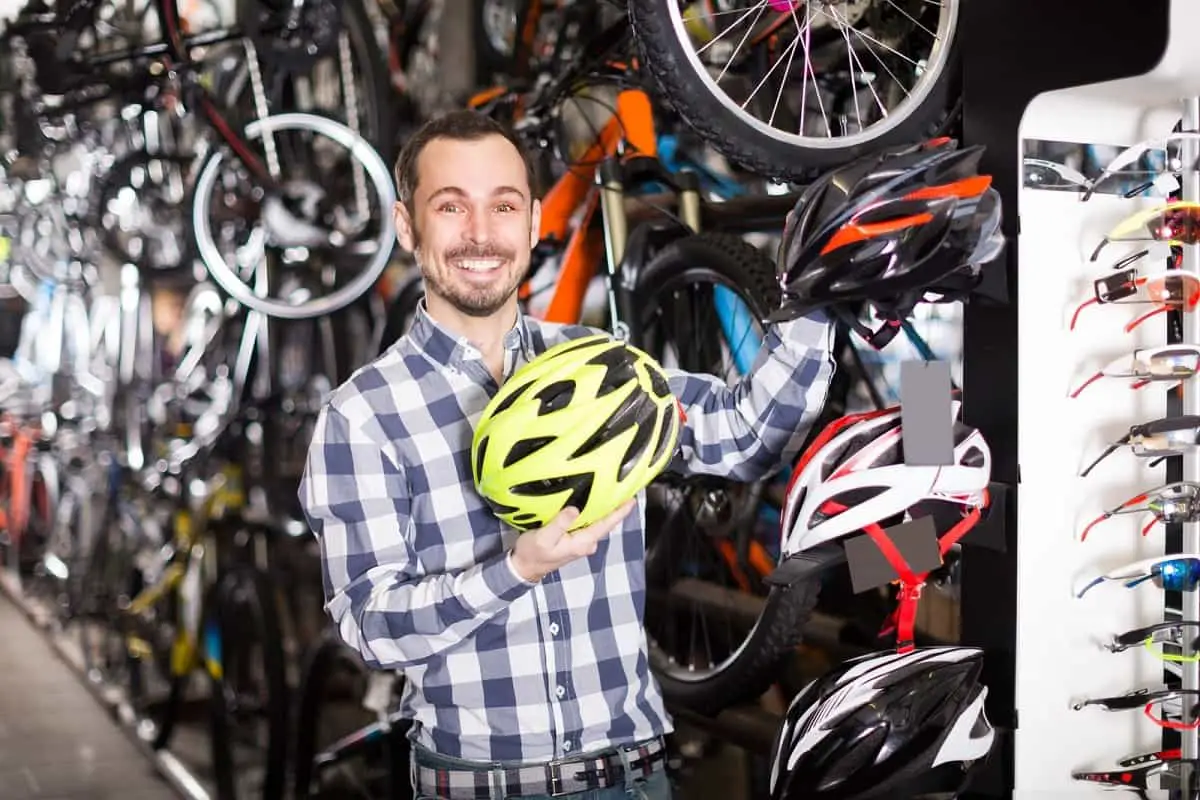 Salesman in shop with bicycle helmets