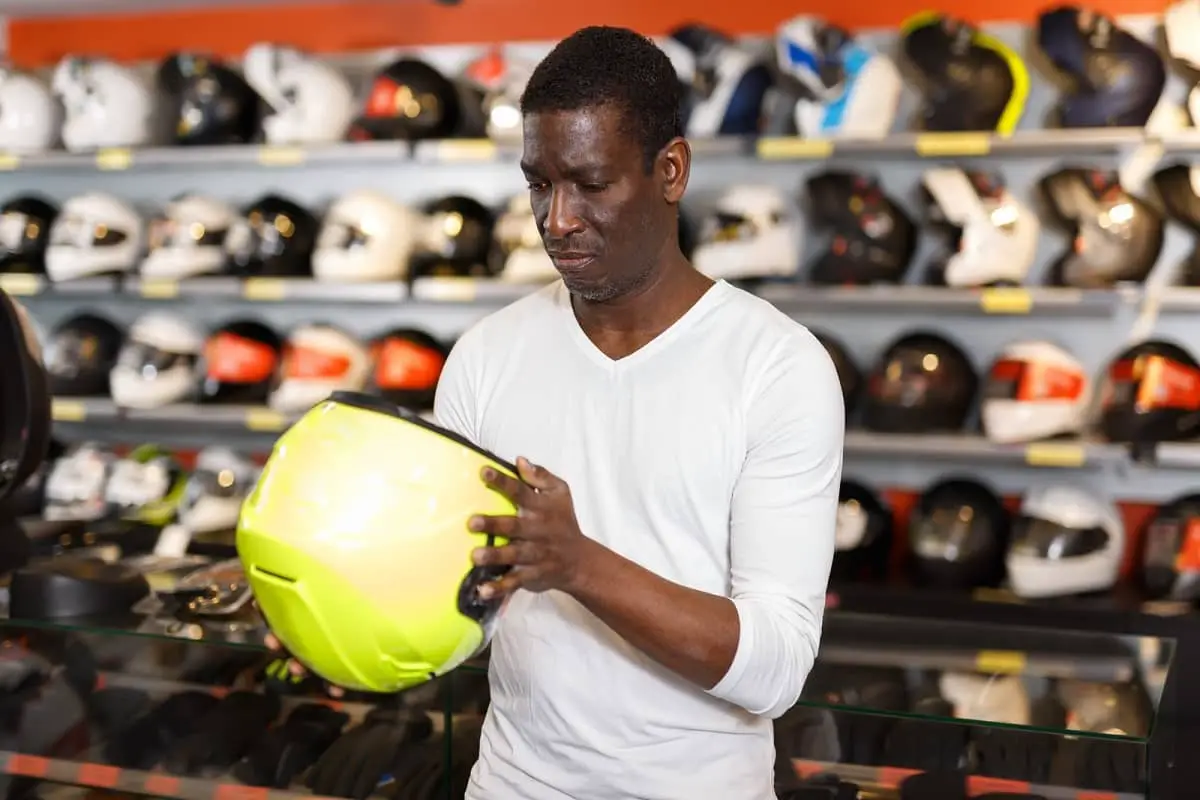 Man looking at helmet with confused look