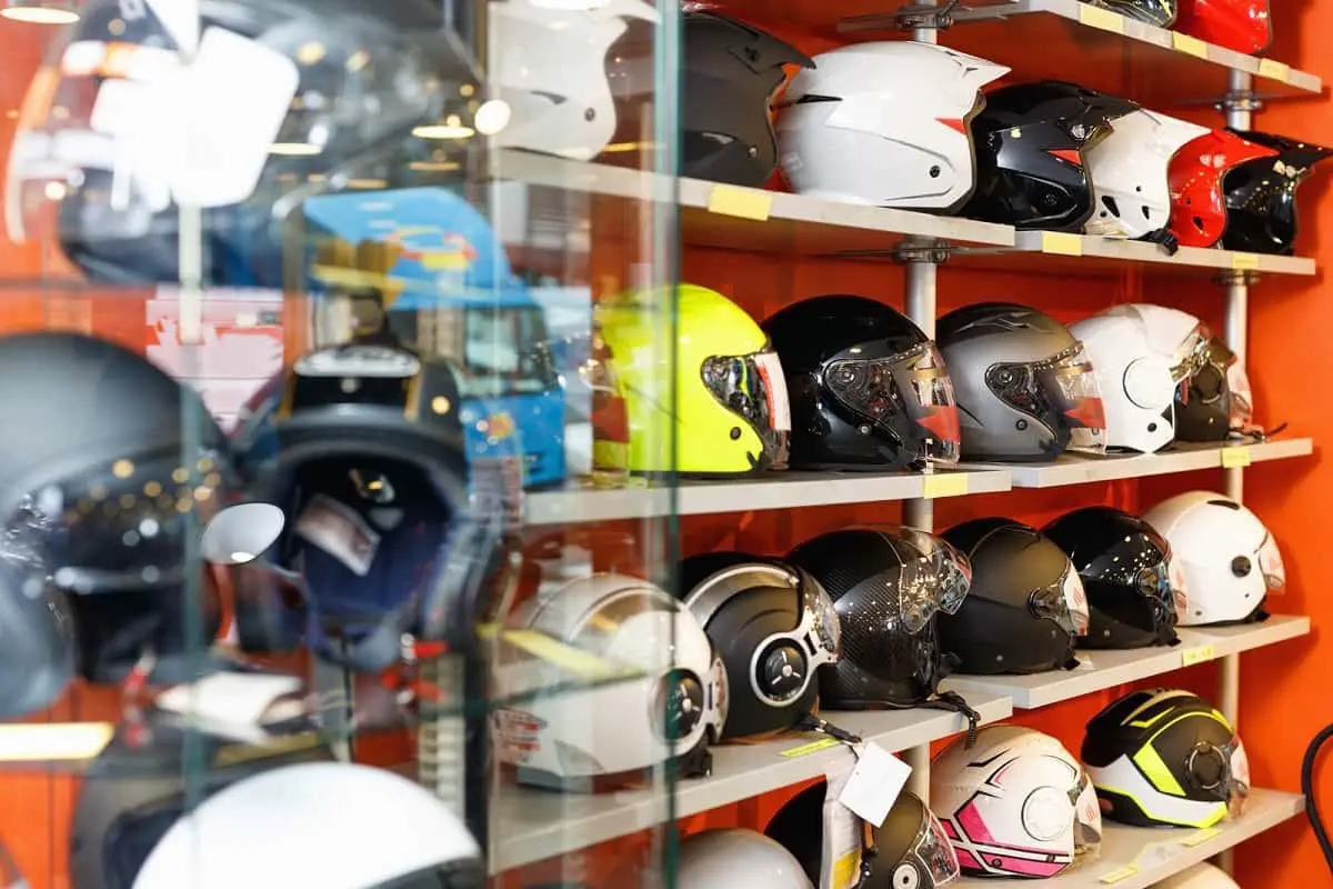 What are motorcycle helmets made of? Motorcycle helmets on the shelf in a showroom.