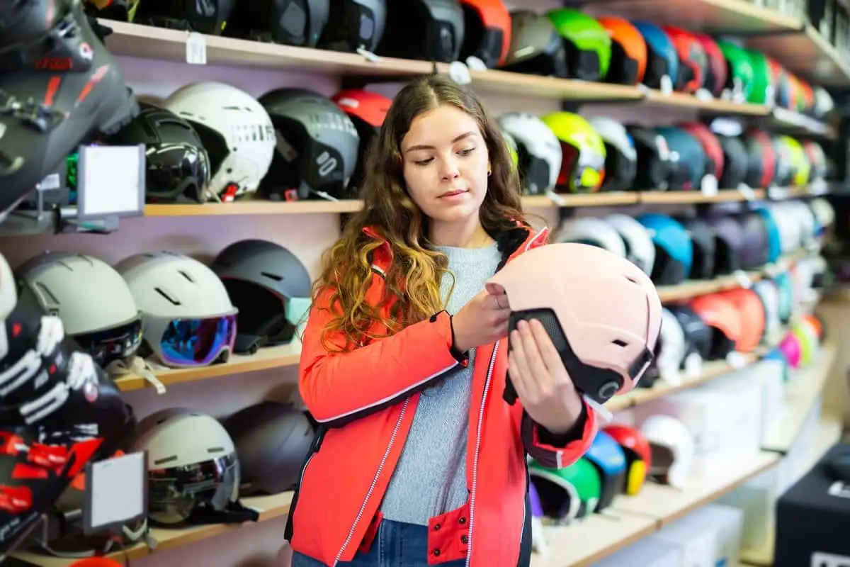 Girl checking pink ski helmet in ski shop