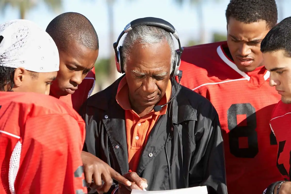 Football coach discussing strategy with his players