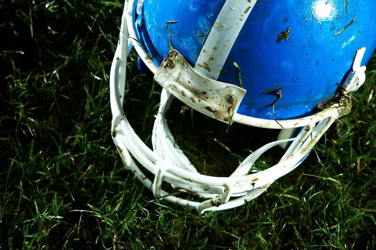 Like it or not, football helmets don't protect against concussion. A soiled blue football helmet on the grass.