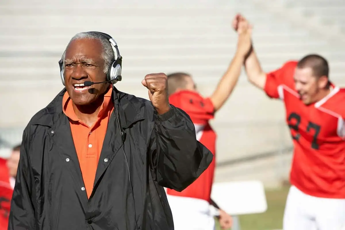 Happy football coach cheering goal