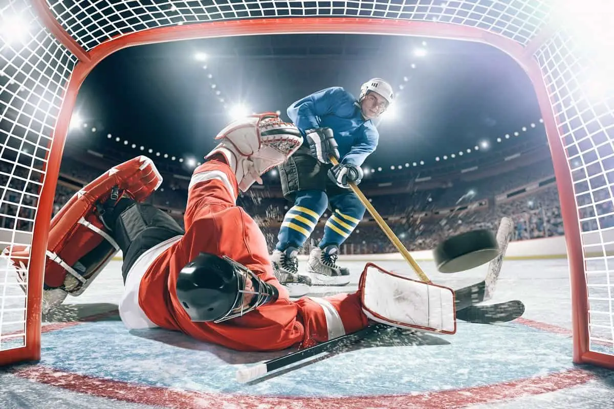 Who was the last NHL player to not wear a helmet?  Not these guys. They're both wearing helmets as one player hits the puck into goal past the goalie.