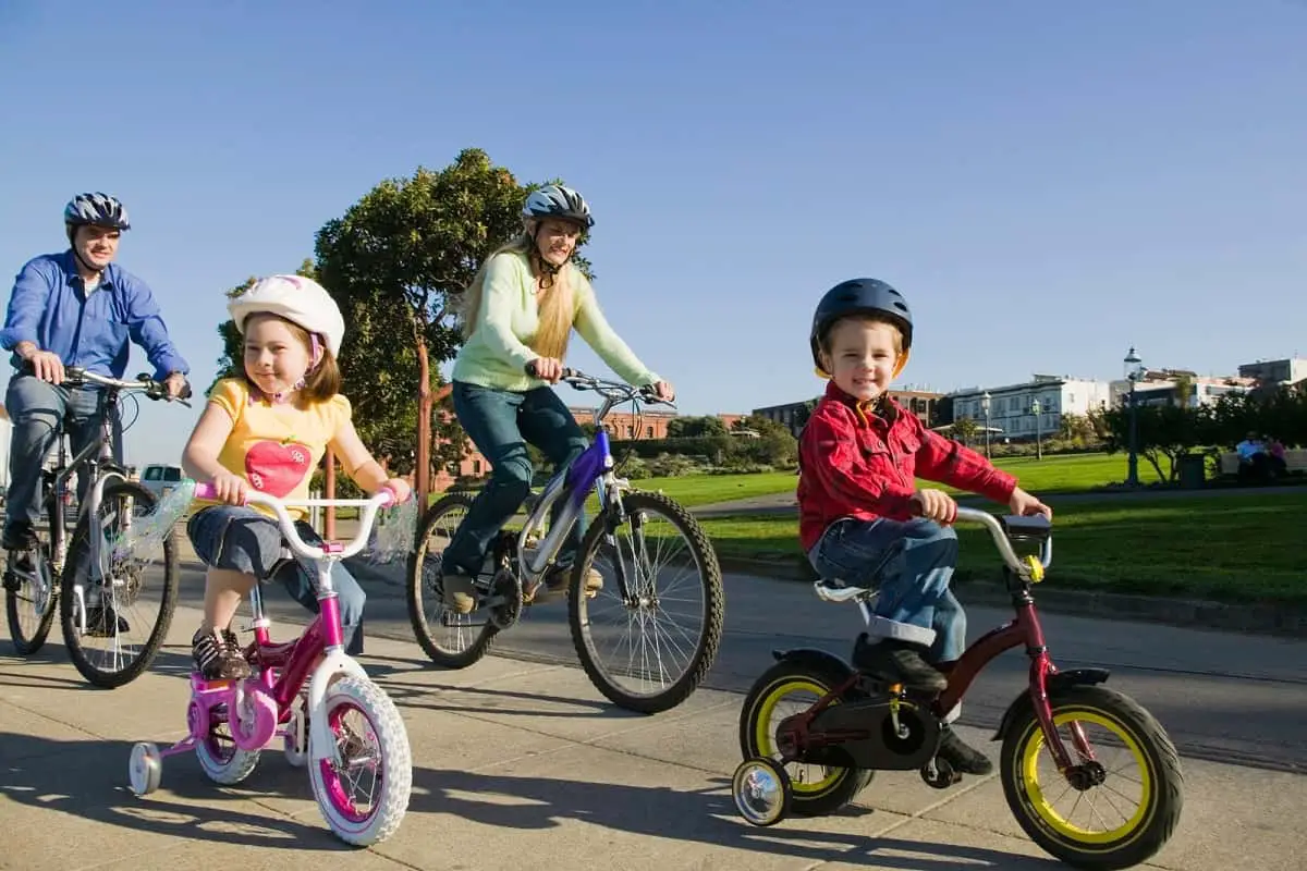 Man and woman with 2 kids riding together wearing cycling helmets