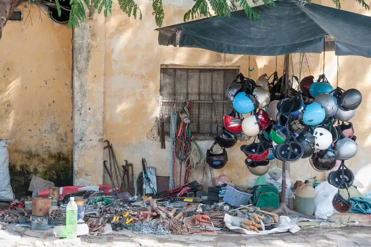 Makeshift roadside market in Vietnam selling motorcycle helmets among other things