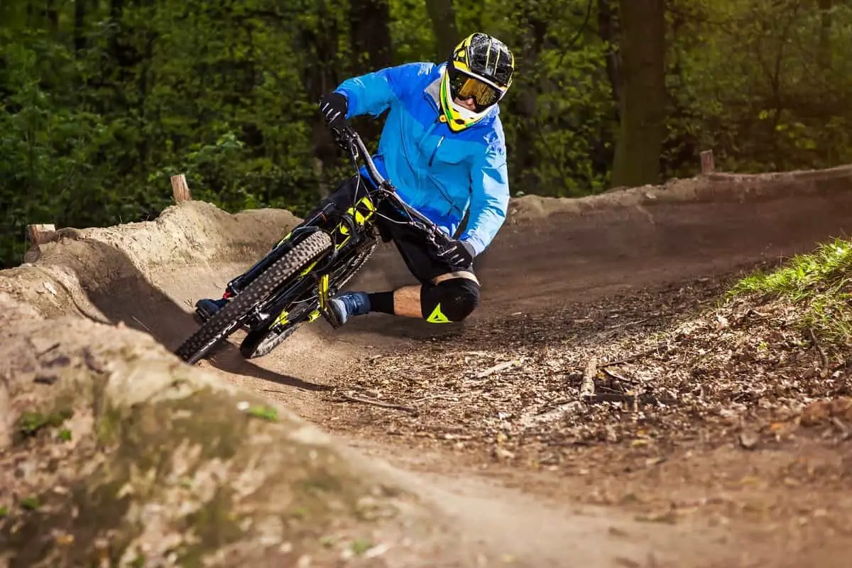 Full-face Vs open-face helmet MTB decision time. This mountain biker in a blue jacket looks good in his full-face helmet.