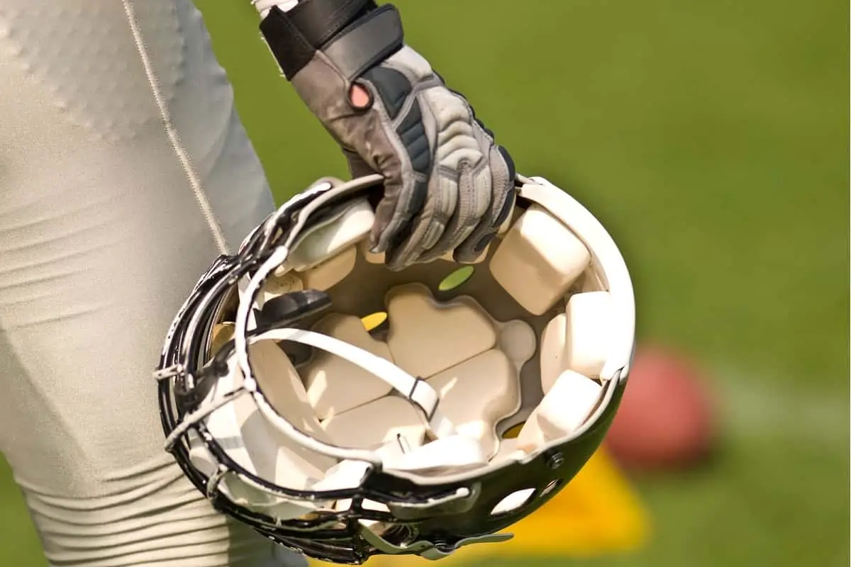 footballer's hand holding helmet showing interior padding of helmet