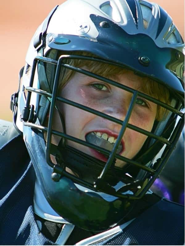 teenage boy wearing lacrosse helmet
