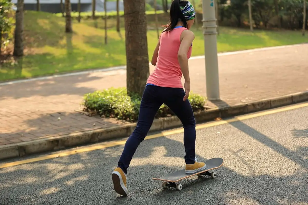 teenage girl skateboarding without a helmet