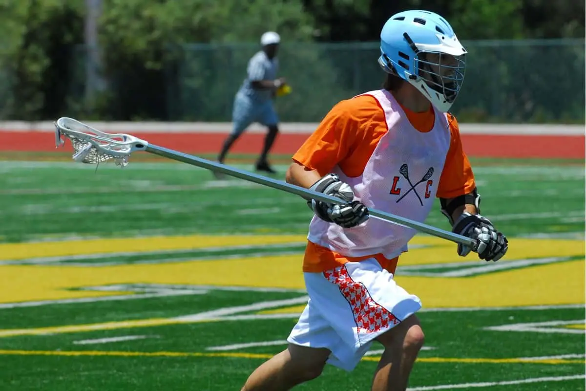 Do Lacrosse Players Wear Helmets? 2 male lacrosse player running and wearing helmet