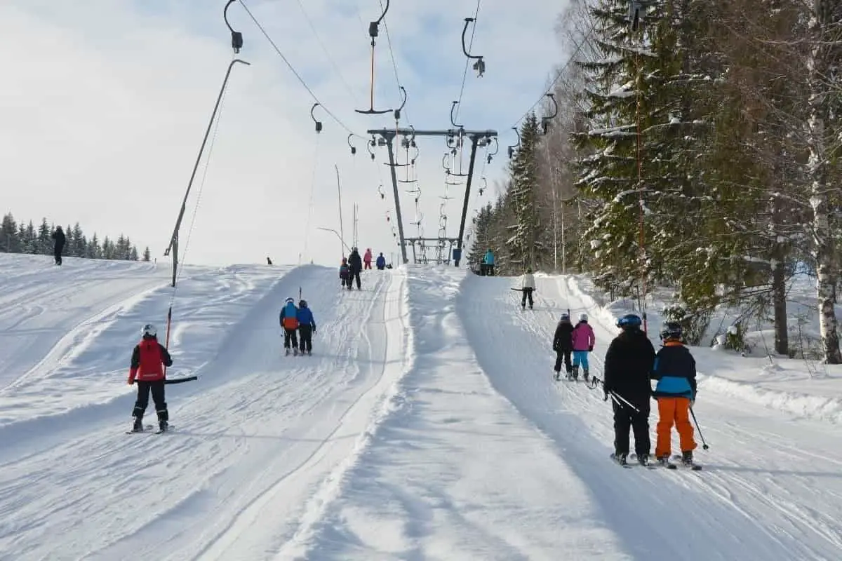 Skiers being pulled up ski slope by ski lift