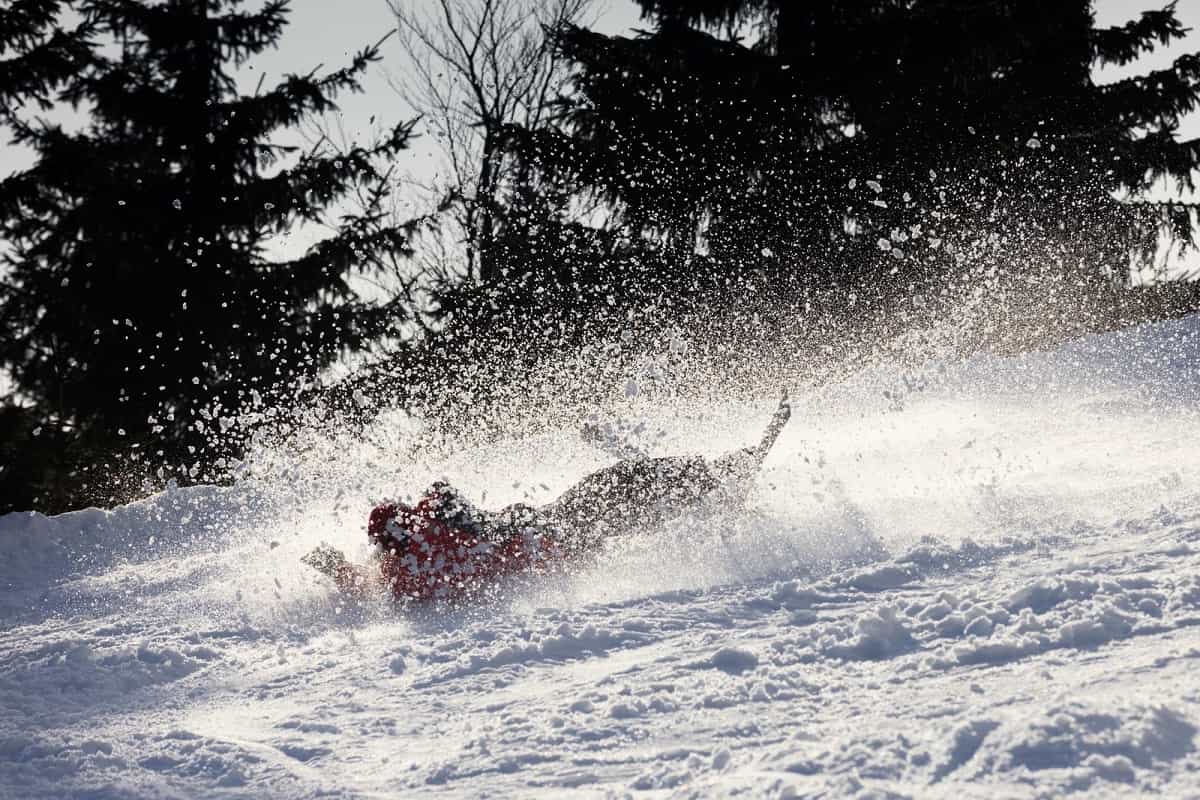 snow skier takes a tumble in the powdery snow