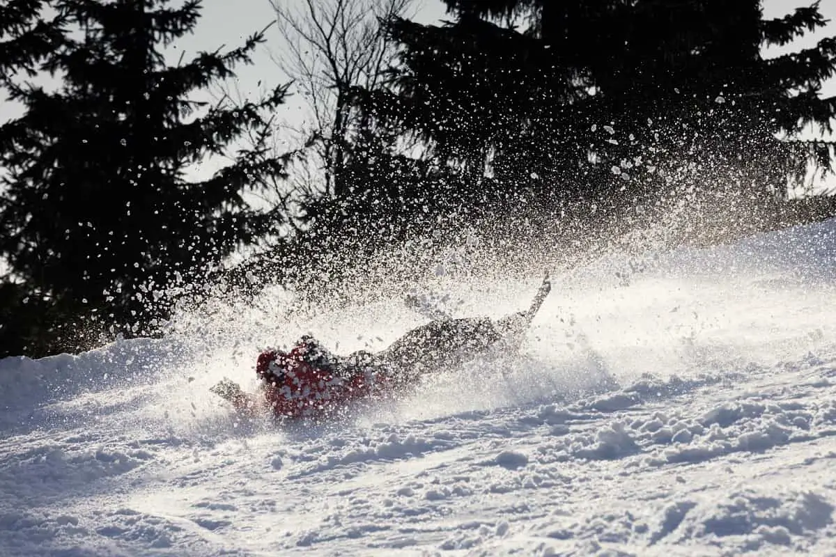 Do You Need A Helmet To Ski? 2 snow skier takes a tumble in the powdery snow