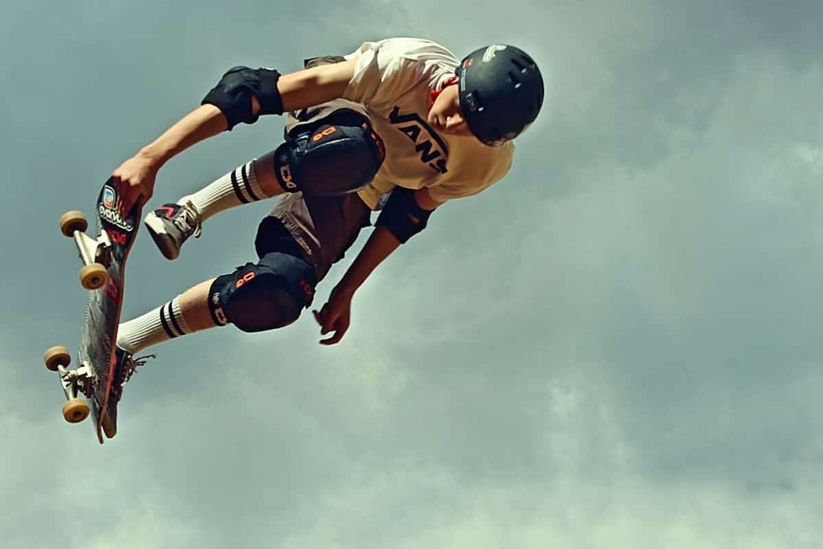 Skateboarder in the sky holding board with his hand