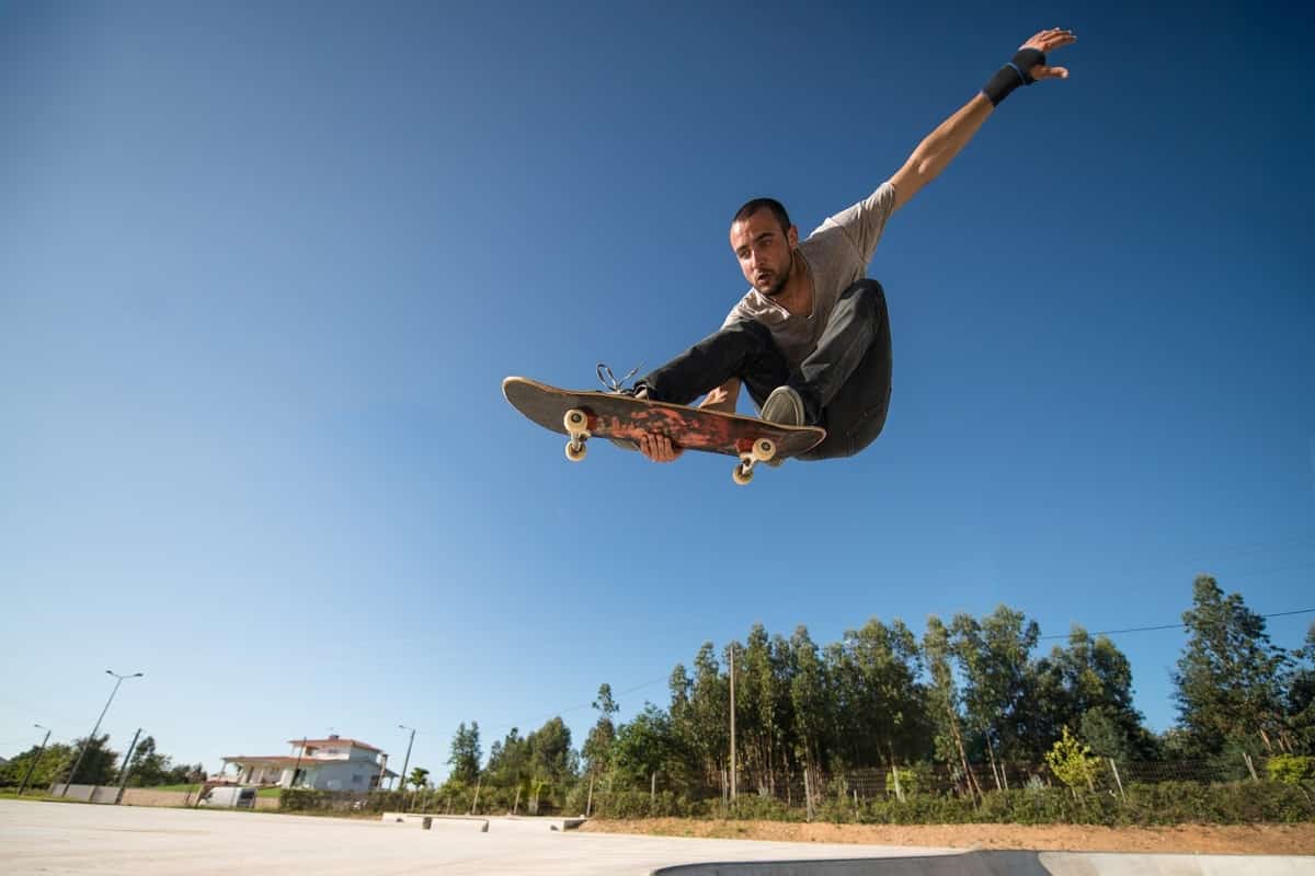 Bearded man without a helmet on a skateboard in mid air.