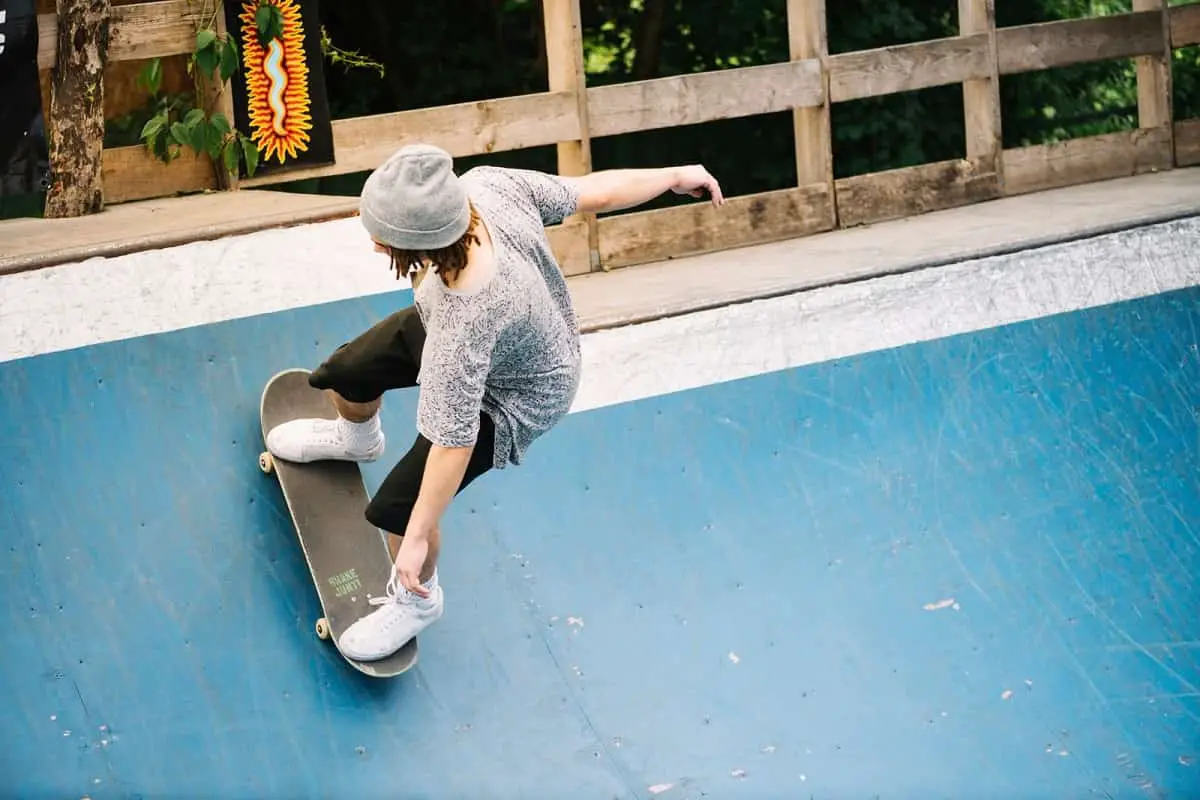 Person riding a skateboard without a helmet at a skate park