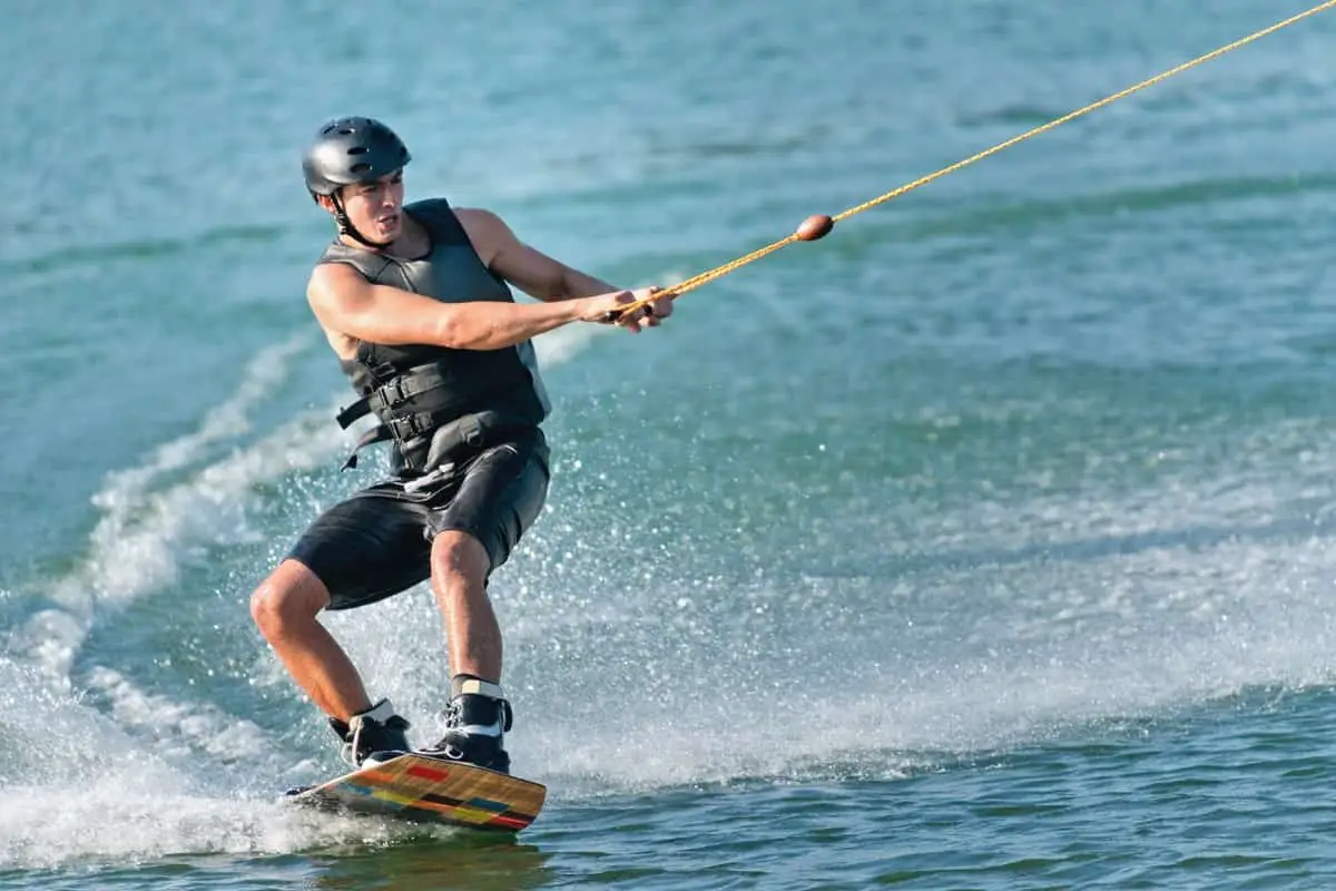 Wakeboarder wearing black EN1385 certified watersports helmet