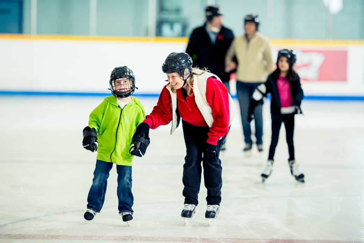 family group ice skating at skating rink