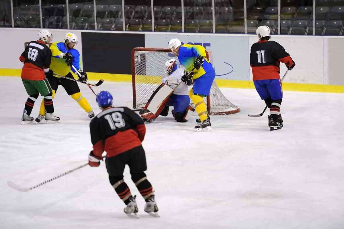 game of ice hockey in progress with several players around the goal area