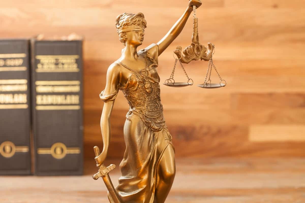 figurine of the scales of justice with two law books in the background