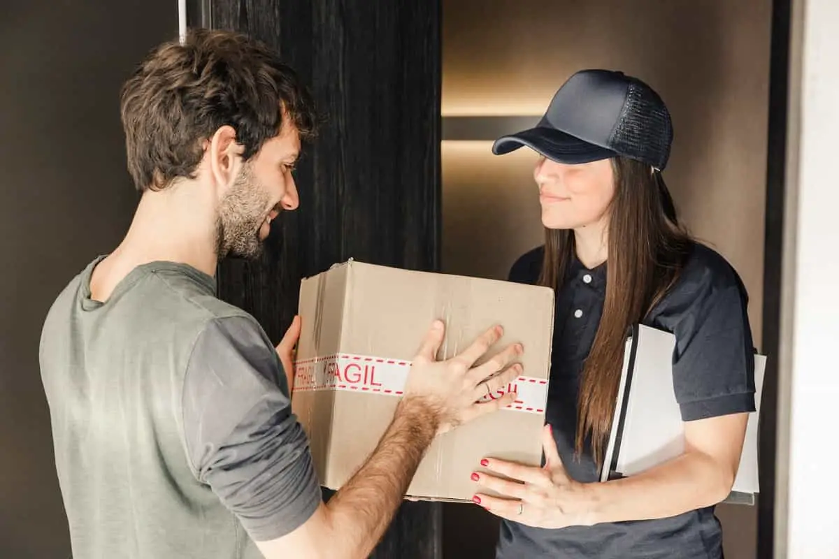 woman courier delivering package to man