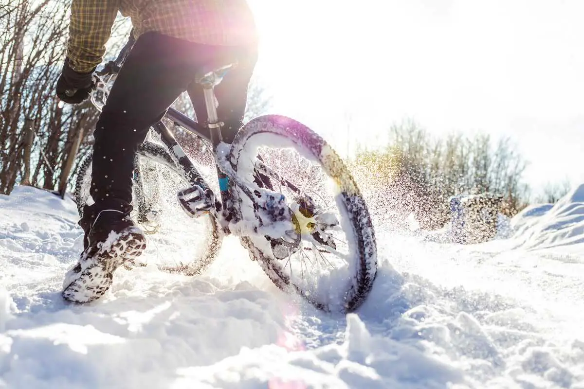 someone riding a bicycle in the fresh snow