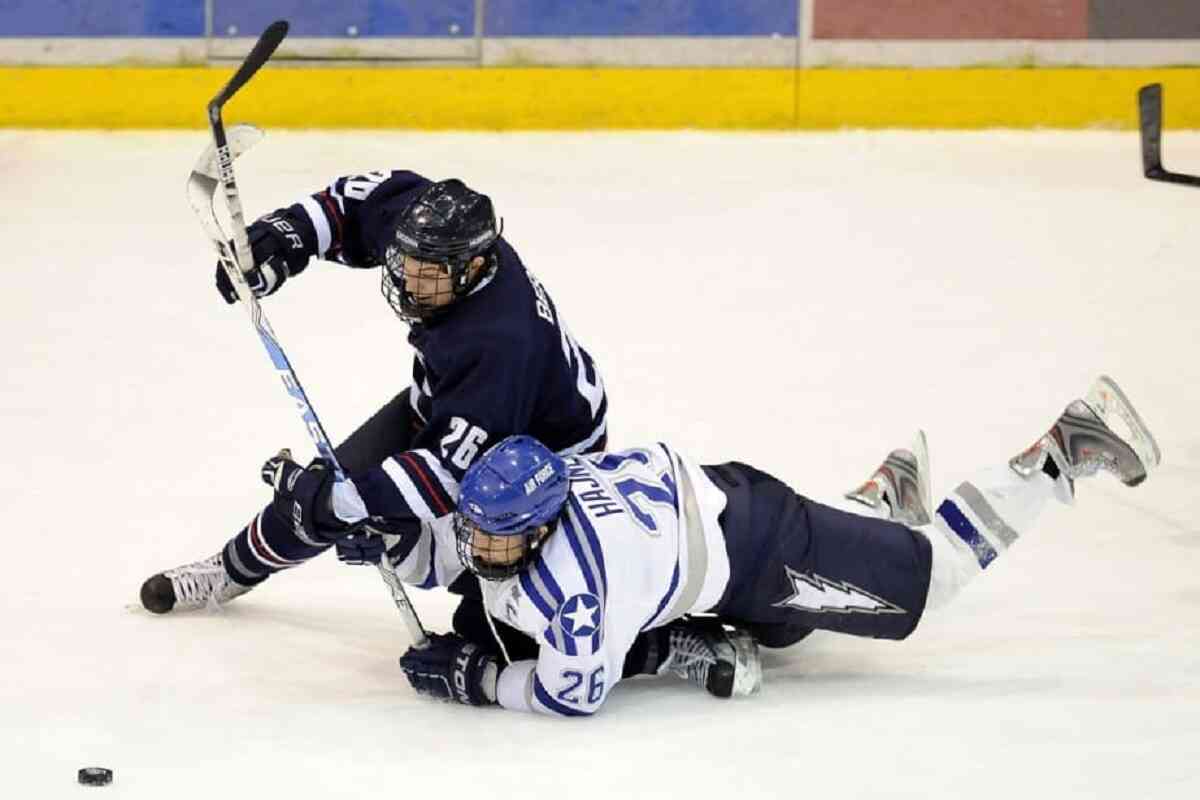 two hockey players scuffling to get to the puck