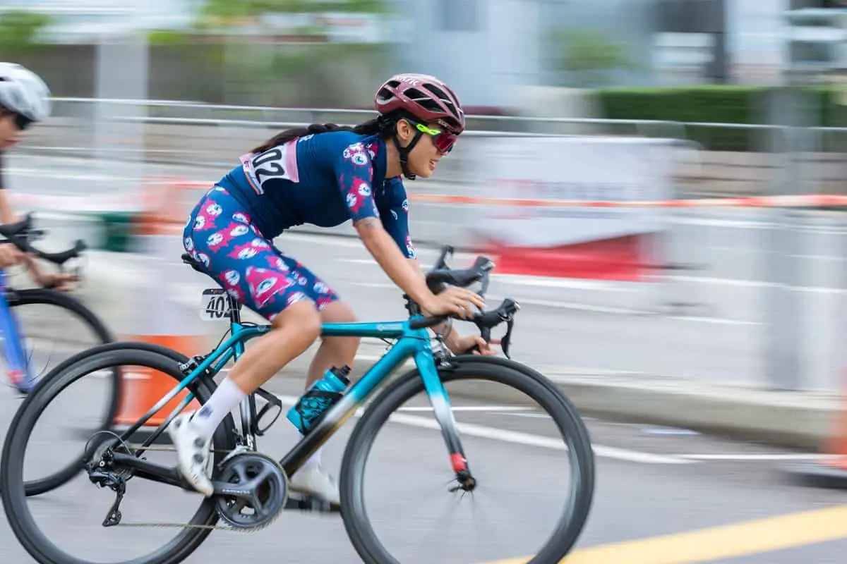 woman in bicycle race wearing red bike helmet