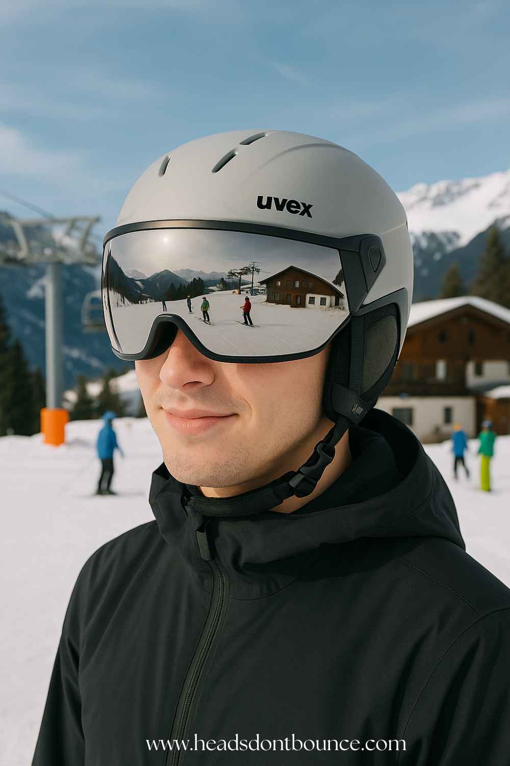 Twenty-year-old male skier wearing a light grey visor helmet; chalet and lift in the distance.