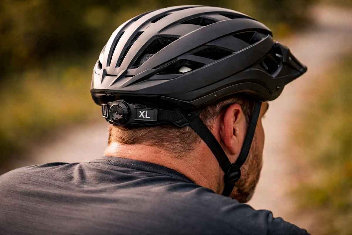 Rear view of cyclist wearing an XL bicycle helmet with size label visible.