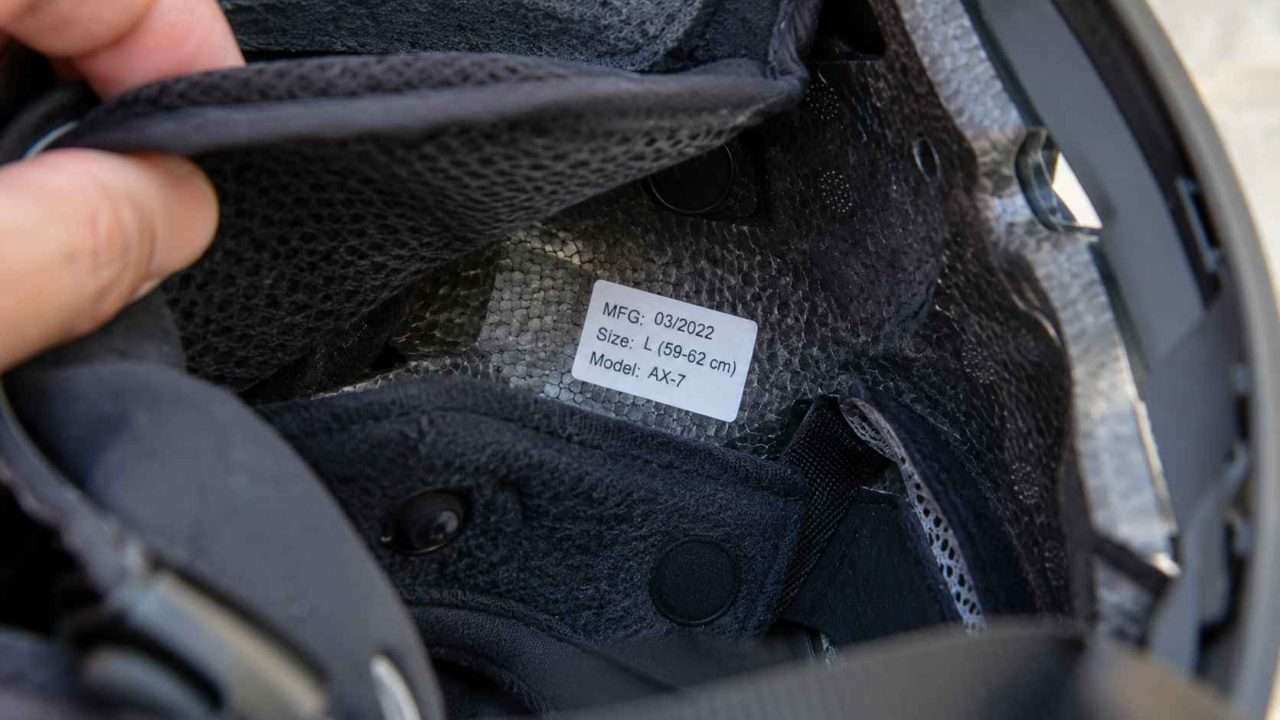 Inside of a ski helmet with the liner peeled back to reveal the manufacture date label.